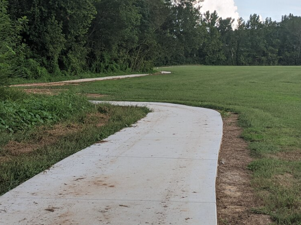 Wateree Veterans Park paved trail winding around a lawn of green grass at Wateree River Veterans Park