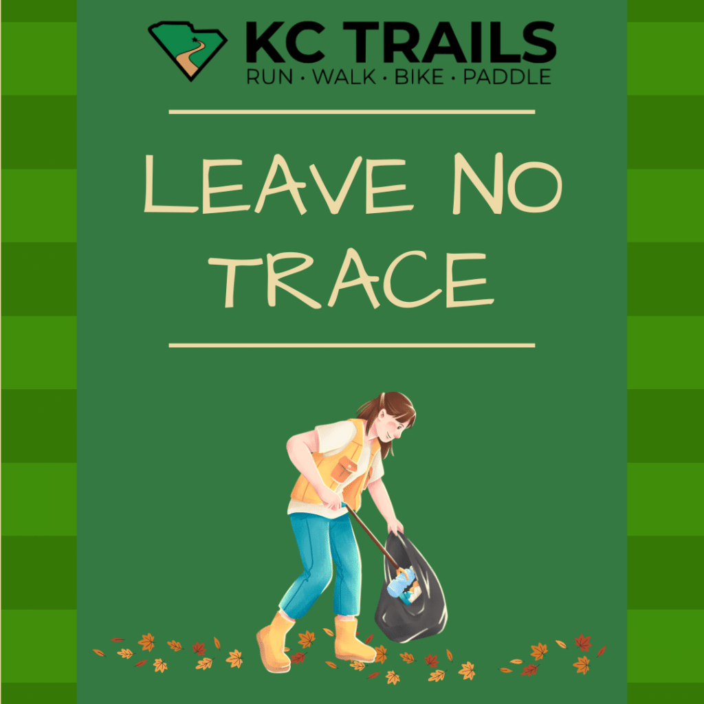 a woman picks up trash while out on a trail