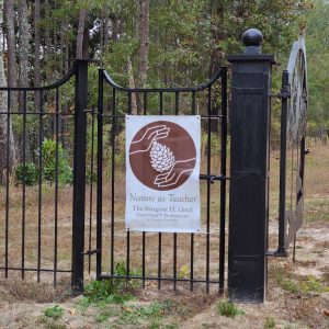 Nature as Teacher Poster attached to a black iron fence with the door open
