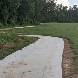 Wateree Veterans Park paved trail winding around a lawn of green grass at Wateree River Veterans Park